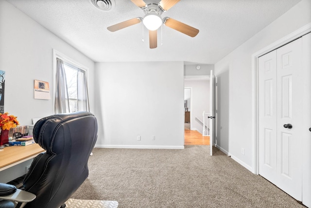 carpeted office featuring ceiling fan and a textured ceiling