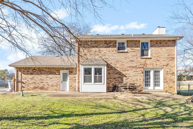 rear view of property featuring a lawn and a patio