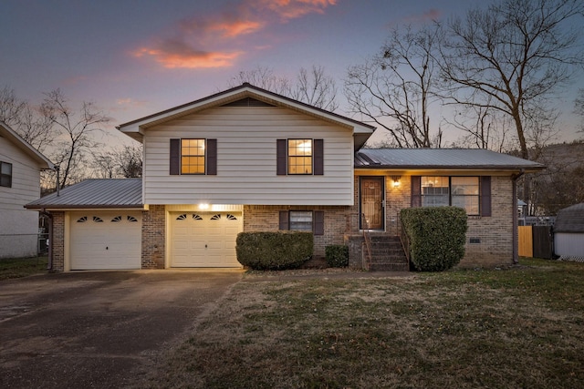 tri-level home with a lawn and a garage