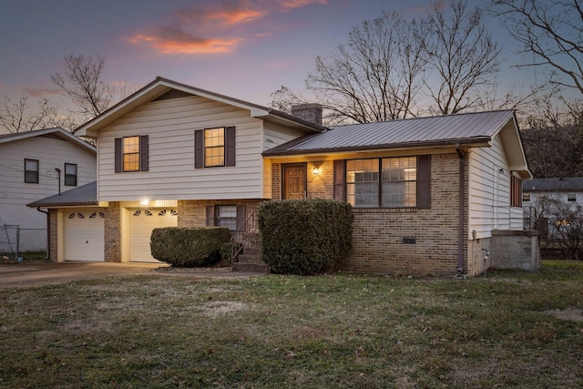 tri-level home featuring a lawn and a garage