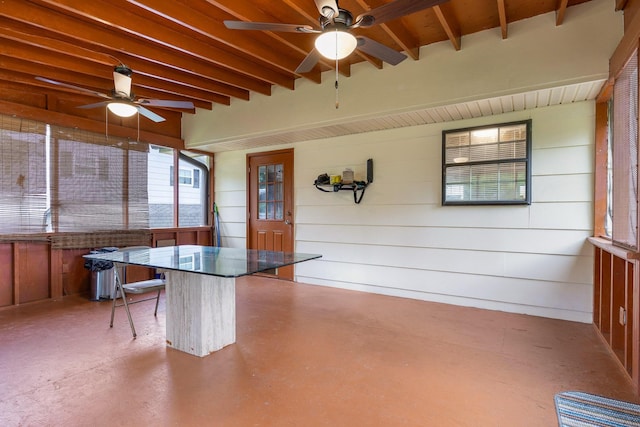 unfurnished sunroom with ceiling fan and beamed ceiling