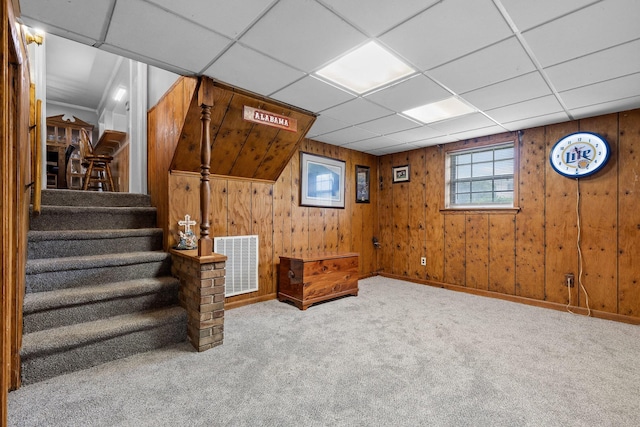 basement with a paneled ceiling and carpet flooring