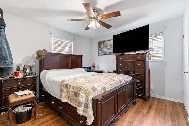 bedroom featuring a textured ceiling, ceiling fan, and light hardwood / wood-style floors