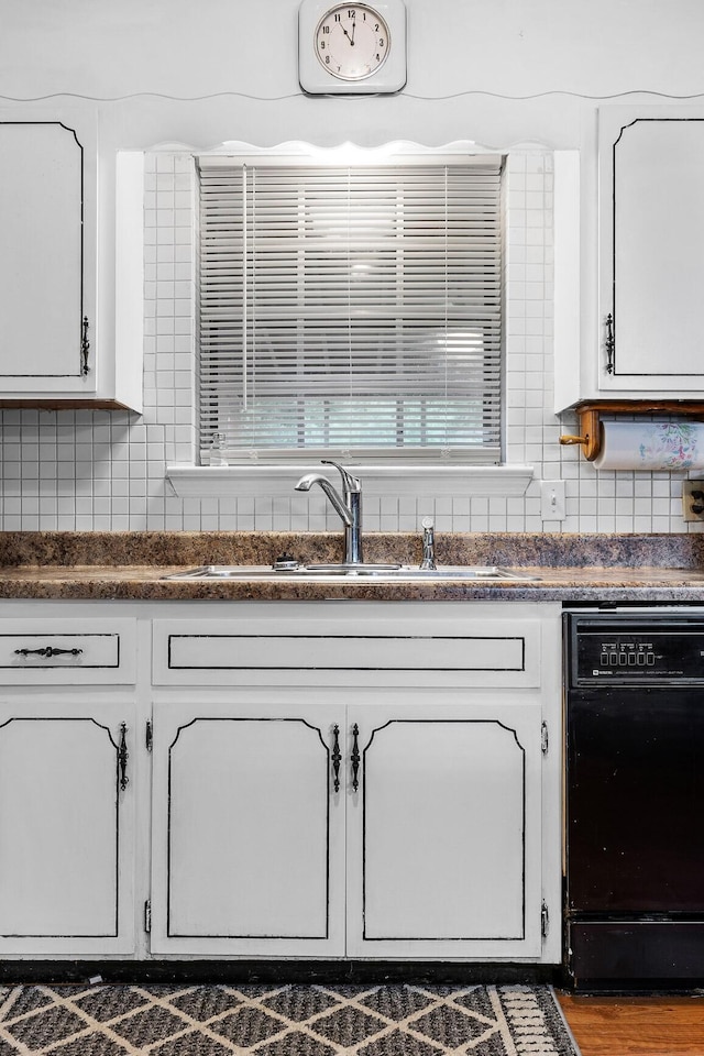 kitchen with sink, white cabinetry, backsplash, and dishwasher