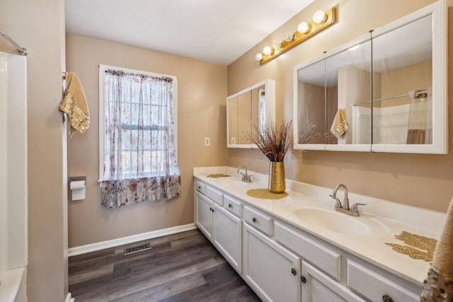 bathroom featuring hardwood / wood-style flooring, a shower, and vanity