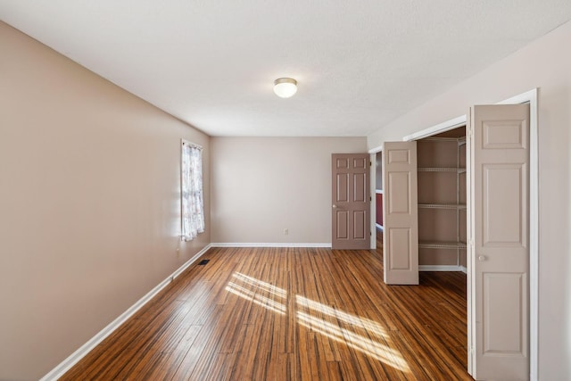 unfurnished bedroom featuring dark hardwood / wood-style flooring and a closet