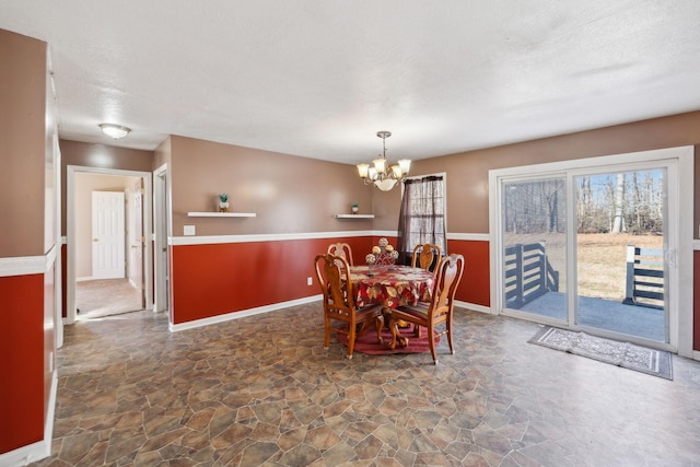 dining space featuring a textured ceiling and a chandelier