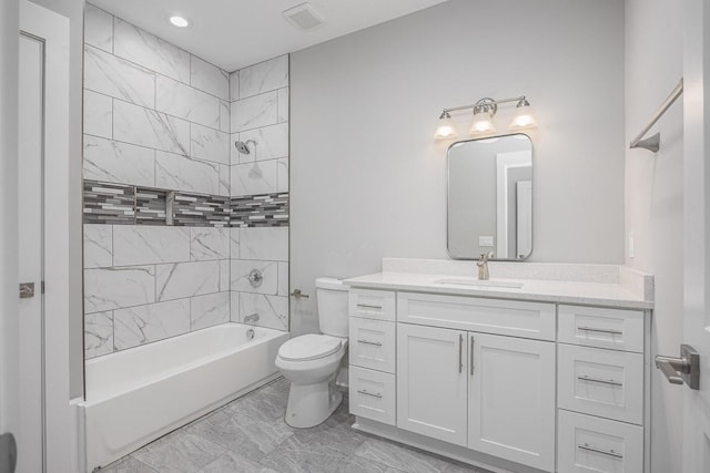 full bathroom with toilet, vanity, and tiled shower / bath