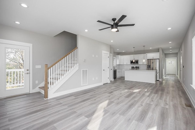 unfurnished living room with ceiling fan and light hardwood / wood-style floors