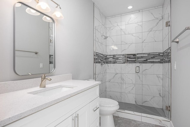 bathroom with toilet, a shower with door, and vanity