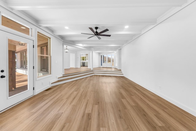 unfurnished living room with ceiling fan, beam ceiling, and light hardwood / wood-style flooring