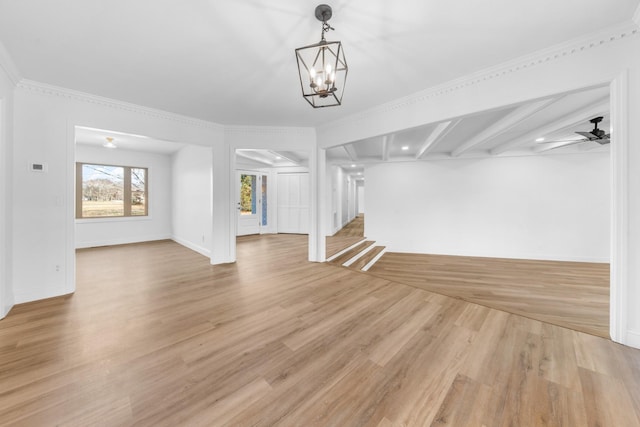 unfurnished living room featuring crown molding, ceiling fan with notable chandelier, and light hardwood / wood-style flooring