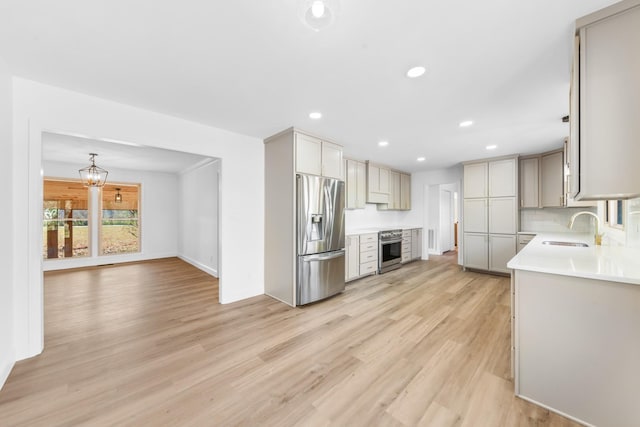 kitchen featuring stainless steel fridge with ice dispenser, wall oven, decorative backsplash, light hardwood / wood-style flooring, and sink