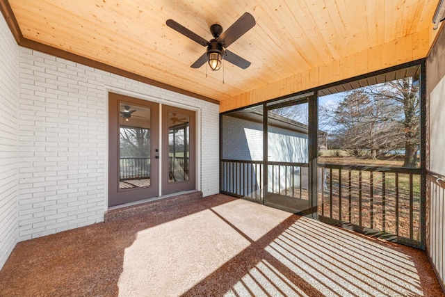 unfurnished sunroom featuring ceiling fan and wood ceiling