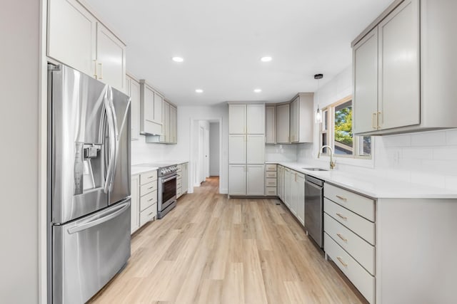 kitchen featuring sink, hanging light fixtures, gray cabinets, and stainless steel appliances