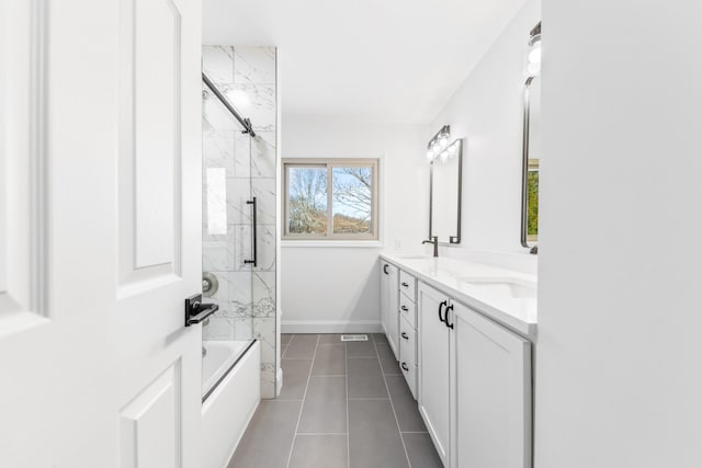 bathroom featuring tile patterned floors, tiled shower / bath, and vanity