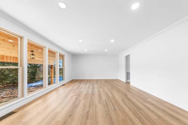 unfurnished living room featuring crown molding and light hardwood / wood-style flooring