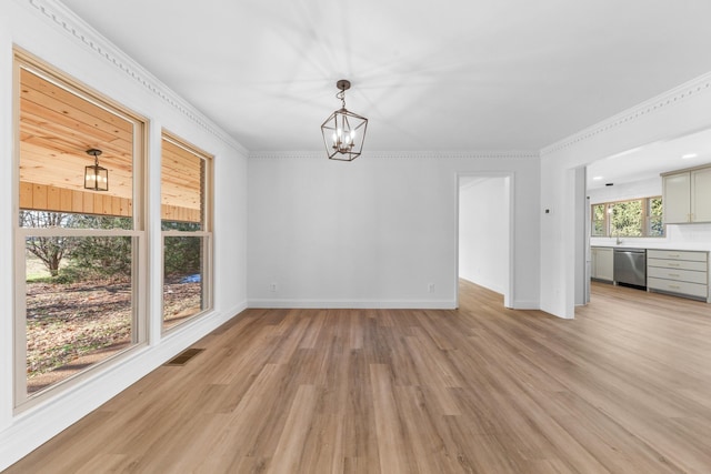 unfurnished dining area featuring an inviting chandelier, crown molding, and light hardwood / wood-style flooring