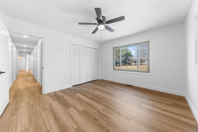 unfurnished bedroom with ceiling fan, a closet, and light hardwood / wood-style floors