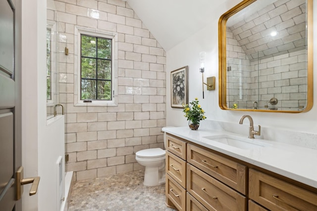 bathroom featuring toilet, walk in shower, lofted ceiling, tile walls, and vanity