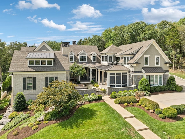 view of front of house featuring a sunroom and a front lawn