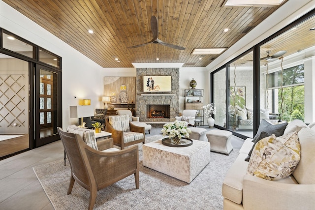 living room with a fireplace, ceiling fan, and wooden ceiling