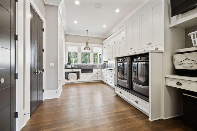 kitchen featuring dark hardwood / wood-style floors, decorative light fixtures, oven, white cabinetry, and sink