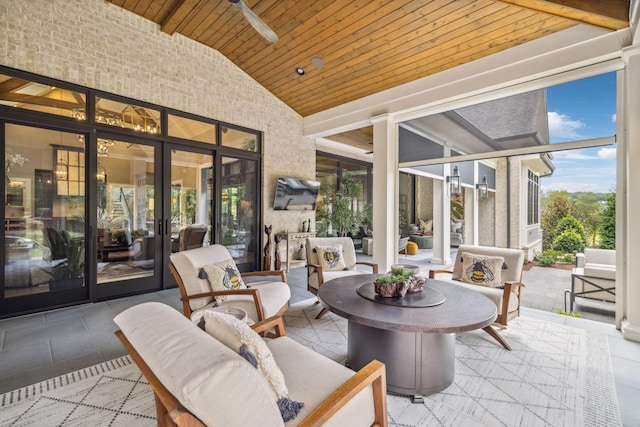 sunroom featuring lofted ceiling, french doors, wooden ceiling, and ceiling fan