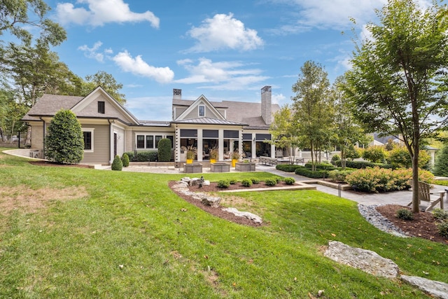 rear view of property featuring a yard and a patio area