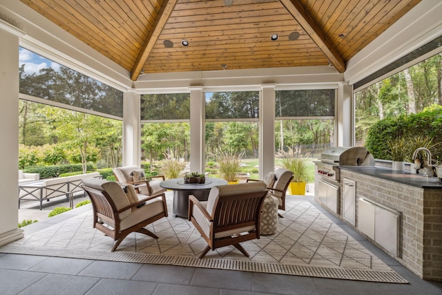 sunroom / solarium featuring vaulted ceiling with beams, wooden ceiling, and sink