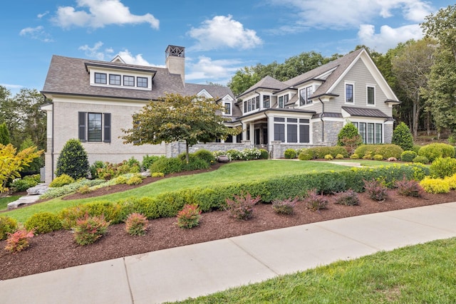 view of front of house with a front yard and a sunroom