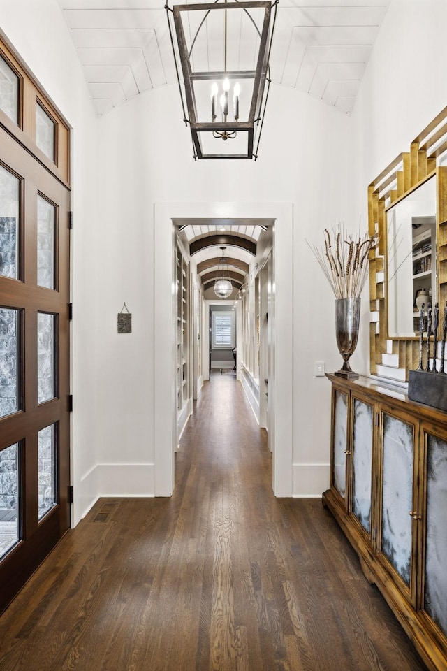 entrance foyer featuring a notable chandelier, wooden ceiling, vaulted ceiling, and dark hardwood / wood-style flooring