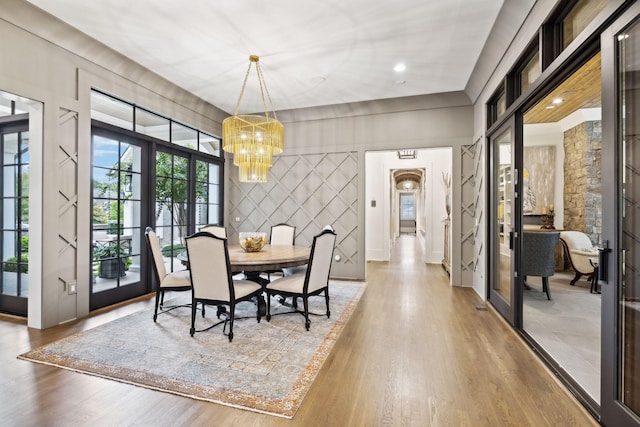 dining area with french doors, a chandelier, and hardwood / wood-style floors