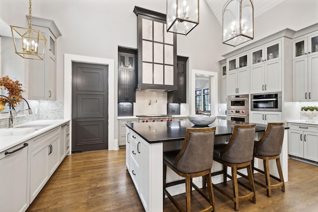 kitchen featuring sink, hanging light fixtures, a kitchen island, and decorative backsplash