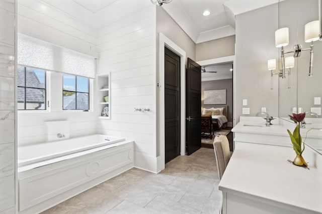 bathroom featuring vanity, a washtub, and crown molding