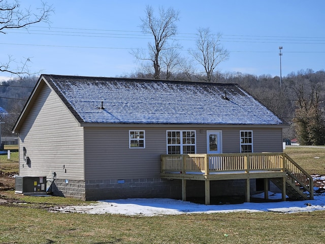 rear view of property with a yard, a wooden deck, and central AC unit