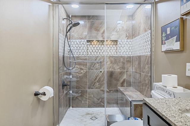 bathroom featuring toilet, a shower with door, and vanity