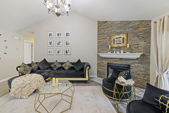 living room featuring hardwood / wood-style floors, an inviting chandelier, vaulted ceiling, and a stone fireplace