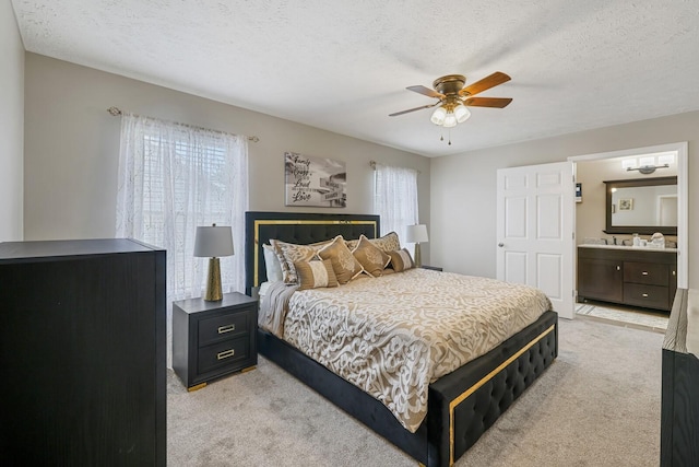 bedroom with a textured ceiling, ceiling fan, and light colored carpet