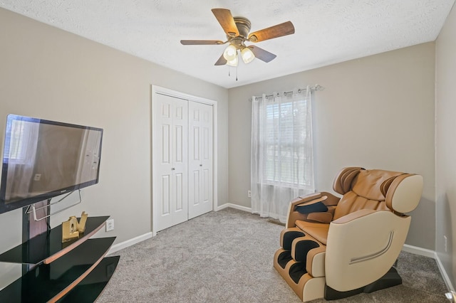 sitting room with light colored carpet, ceiling fan, and a textured ceiling