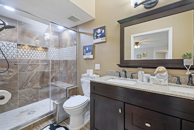 bathroom featuring tile patterned flooring, a shower with shower door, ceiling fan, toilet, and vanity