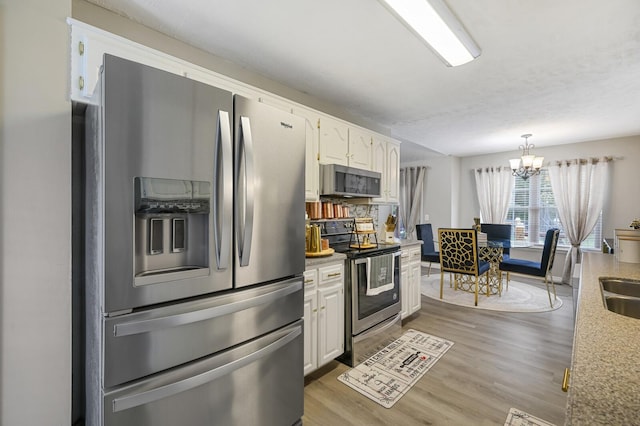 kitchen with an inviting chandelier, stainless steel appliances, dark hardwood / wood-style flooring, white cabinets, and decorative light fixtures