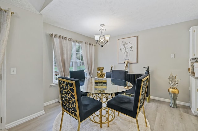 dining area featuring light wood-type flooring and a chandelier