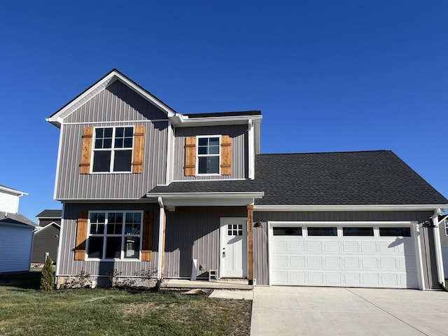 view of front of home featuring a porch, a front lawn, and a garage