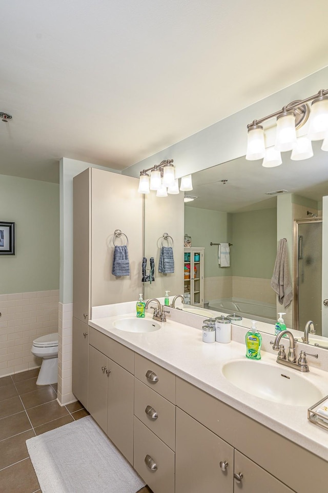 full bathroom featuring shower with separate bathtub, tile walls, toilet, tile patterned floors, and vanity