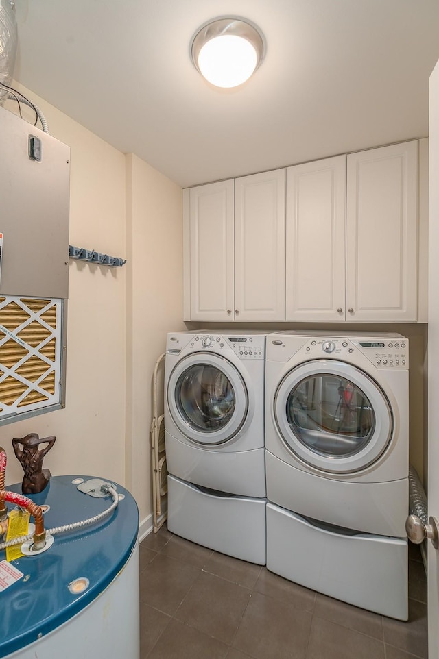 washroom featuring cabinets, separate washer and dryer, and dark tile patterned floors