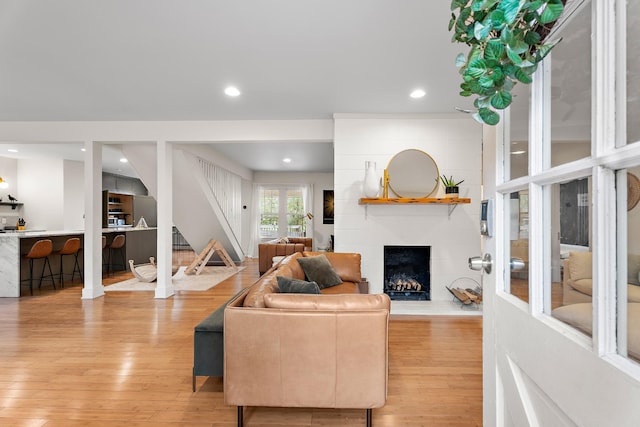 living room with light wood-type flooring and a large fireplace