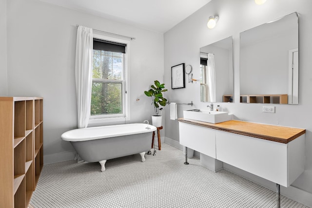 bathroom featuring vanity, tile patterned floors, and a tub to relax in