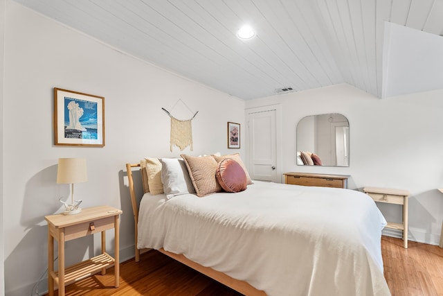 bedroom featuring lofted ceiling, wooden ceiling, and light wood-type flooring