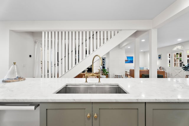 kitchen featuring gray cabinetry, light stone countertops, and sink